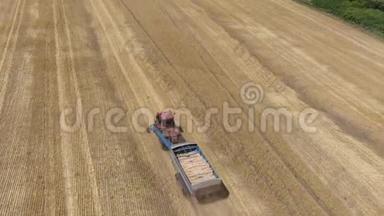 卡特彼勒拖拉机带着一辆拖车正驶过收获的麦田